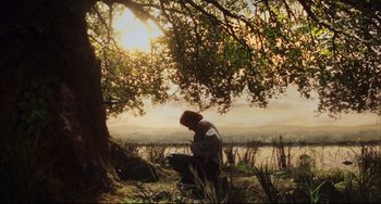 Movie still from “The Fountain” (2006), directed by Darren Aronofsky – A man sitting under a tree in the grass; Wide shot, Low angle