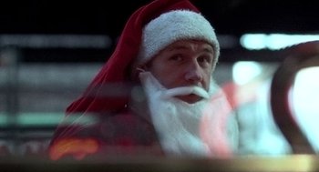Movie still from “The French Connection” (1971), directed by William Friedkin – A man wearing a santa claus hat and beard; Close Up shot, Low angle