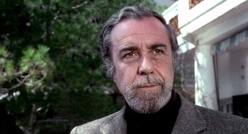 Movie still from “The French Connection” (1971), directed by William Friedkin – An older man wearing a jacket and a black shirt; Close Up shot, Low angle