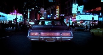 Movie still from “The French Connection” (1971), directed by William Friedkin – The back end of a car on the street at night; Wide shot, Low angle