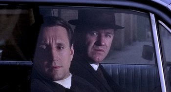 Movie still from “The French Connection” (1971), directed by William Friedkin – A couple of men sitting in the back of a car; Close Up shot, Over the shoulder angle