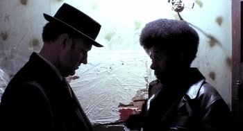 Movie still from “The French Connection” (1971), directed by William Friedkin – A man in a hat and a man in a black jacket; Close Up shot, Low angle