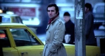 Movie still from “The French Connection” (1971), directed by William Friedkin – A man standing next to a yellow taxi cab; Medium shot, Low angle