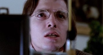 Movie still from “The French Connection” (1971), directed by William Friedkin – A person wearing glasses and looking at the camera; Close Up shot, Low angle