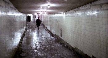 Movie still from “The French Connection” (1971), directed by William Friedkin – A person is walking down a hallway in a building; Extreme Wide shot, High angle