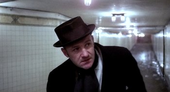 Movie still from “The French Connection” (1971), directed by William Friedkin – A man wearing a hat and a tie; Close Up shot, Low angle