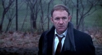 Movie still from “The French Connection” (1971), directed by William Friedkin – A person wearing a suit and tie; Close Up shot, Low angle