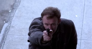Movie still from “The French Connection” (1971), directed by William Friedkin – A man holding a gun in his hand; Close Up shot, Low angle