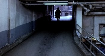 Movie still from “The French Connection” (1971), directed by William Friedkin – A person is walking in a dark alley way; Wide shot, High angle