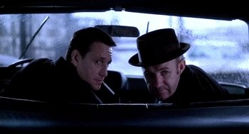 Movie still from “The French Connection” (1971), directed by William Friedkin – A couple of men sitting in the back of a car; Close Up shot, Low angle