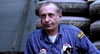 Movie still from “The French Connection” (1971), directed by William Friedkin – An older man in a blue work shirt; Close Up shot, Low angle