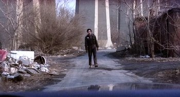 A man riding a skateboard down the side of a road