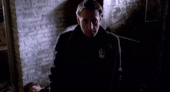 Movie still from “The French Connection” (1971), directed by William Friedkin – A man standing in the dark wearing a jacket; Close Up shot, Low angle