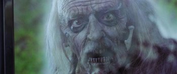 Movie still from “The Frighteners” (1996), directed by Peter Jackson – An old man's face is painted in white and blue; Close Up shot, Low angle
