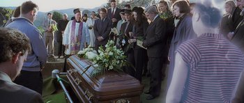 Movie still from “The Frighteners” (1996), directed by Peter Jackson – A group of people standing around a casket; Medium shot, High angle