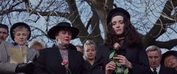Movie still from “The Frighteners” (1996), directed by Peter Jackson – Two women holding roses in front of a group of people; Medium shot, High angle