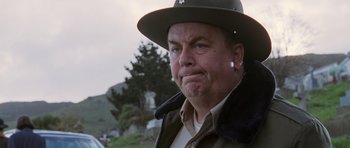 Movie still from “The Frighteners” (1996), directed by Peter Jackson – A person wearing a hat; Close Up shot, Low angle
