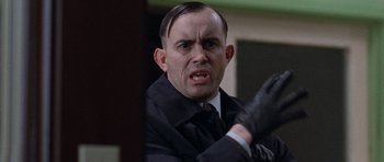 Movie still from “The Frighteners” (1996), directed by Peter Jackson – A person wearing a suit and tie; Close Up shot, Low angle