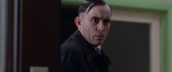 Movie still from “The Frighteners” (1996), directed by Peter Jackson – A person wearing a suit and tie; Close Up shot, Low angle