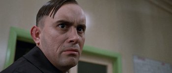 Movie still from “The Frighteners” (1996), directed by Peter Jackson – A man's face in a room with green walls; Close Up shot, Low angle