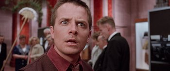 Movie still from “The Frighteners” (1996), directed by Peter Jackson – A person wearing a suit and tie; Close Up shot, Low angle