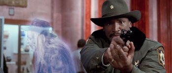 Movie still from “The Frighteners” (1996), directed by Peter Jackson – A man holding a gun pointed at the camera; Close Up shot, Over the shoulder angle