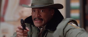 Movie still from “The Frighteners” (1996), directed by Peter Jackson – A person wearing a hat and a jacket; Close Up shot, Low angle