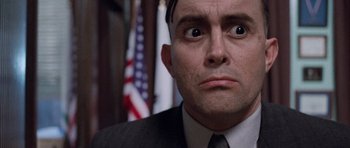 Movie still from “The Frighteners” (1996), directed by Peter Jackson – A person wearing a suit and tie; Close Up shot, Low angle