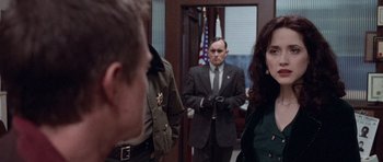 Movie still from “The Frighteners” (1996), directed by Peter Jackson – A man and a woman standing in front of an officer; Medium shot, Over the shoulder angle