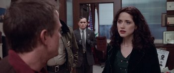Movie still from “The Frighteners” (1996), directed by Peter Jackson – A group of people standing in front of a door; Medium shot, Over the shoulder angle
