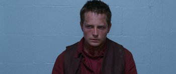 Movie still from “The Frighteners” (1996), directed by Peter Jackson – A person wearing a shirt and vest; Close Up shot, High angle