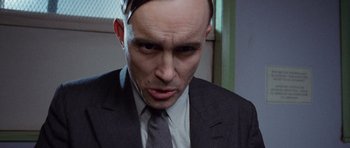 Movie still from “The Frighteners” (1996), directed by Peter Jackson – A person wearing a suit and tie; Close Up shot, Low angle