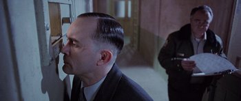 Movie still from “The Frighteners” (1996), directed by Peter Jackson – A man in a black suit and a woman in a black suit; Close Up shot, Over the shoulder angle