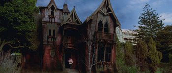 Movie still from “The Frighteners” (1996), directed by Peter Jackson – An old house with a tree in front of it; Wide shot, Low angle