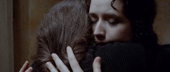 Movie still from “The Frighteners” (1996), directed by Peter Jackson – A woman hugging another woman with her eyes closed; Extreme Close Up shot, Overhead angle