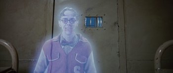 Movie still from “The Frighteners” (1996), directed by Peter Jackson – A man with glasses and a bow tie standing in front of a window; Medium shot, Over the shoulder angle
