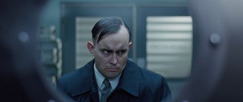 Movie still from “The Frighteners” (1996), directed by Peter Jackson – A person wearing a suit and tie; Close Up shot, Over the shoulder angle
