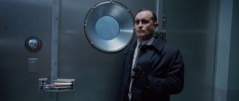Movie still from “The Frighteners” (1996), directed by Peter Jackson – A man standing in front of a metal door; Medium shot, Low angle