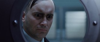 Movie still from “The Frighteners” (1996), directed by Peter Jackson – A person wearing a suit and tie; Close Up shot, Low angle