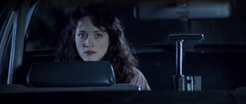 Movie still from “The Frighteners” (1996), directed by Peter Jackson – A woman sitting in the back seat of a car at night; Close Up shot, High angle