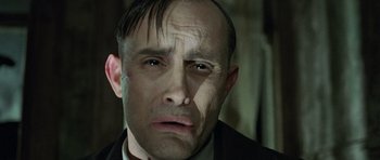 Movie still from “The Frighteners” (1996), directed by Peter Jackson – A person wearing a suit and tie; Close Up shot, Low angle