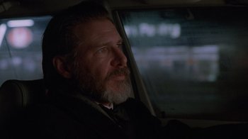 Movie still from “The Fugitive” (1993), directed by Andrew Davis – A man sitting in a car looking out the window; Close Up shot, Low angle