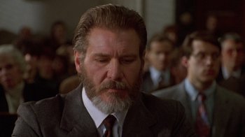 Movie still from “The Fugitive” (1993), directed by Andrew Davis – An older man in a suit and a tie; Close Up shot, Low angle