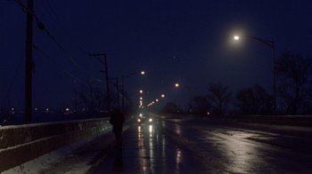 Movie still from “The Fugitive” (1993), directed by Andrew Davis – A person walking down a street at night; Extreme Wide shot, High angle