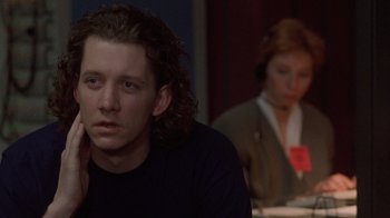 Movie still from “The Fugitive” (1993), directed by Andrew Davis – A man sitting in front of a woman in a room; Close Up shot, Over the shoulder angle