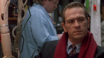 Movie still from “The Fugitive” (1993), directed by Andrew Davis – A person wearing a suit and tie; Close Up shot, Over the shoulder angle