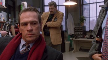 Movie still from “The Fugitive” (1993), directed by Andrew Davis – A man in a suit and a red scarf standing in front of another man; Close Up shot, Over the shoulder angle