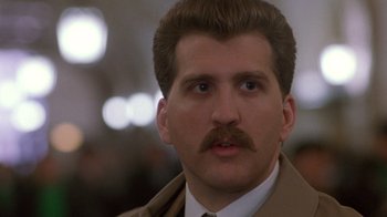 Movie still from “The Fugitive” (1993), directed by Andrew Davis – A person wearing a suit and tie; Close Up shot, Low angle