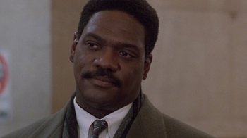 Movie still from “The Fugitive” (1993), directed by Andrew Davis – A person wearing a suit and tie; Close Up shot, Low angle