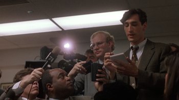 Movie still from “The Fugitive” (1993), directed by Andrew Davis – A group of men standing next to each other holding microphones; Close Up shot, Low angle